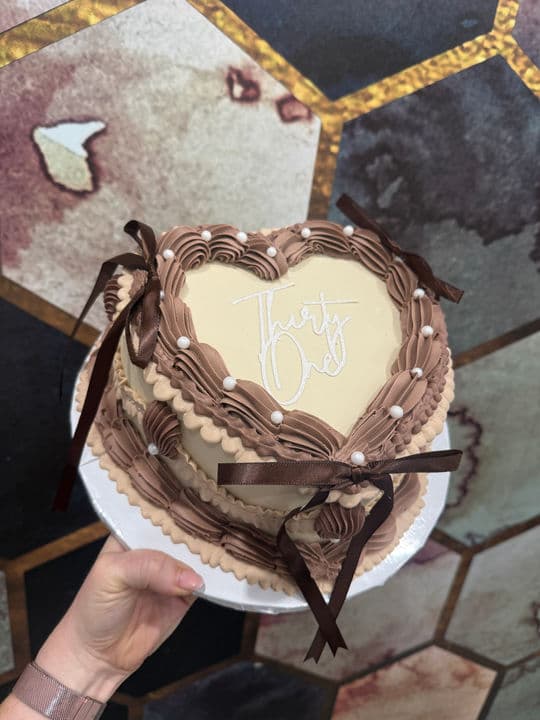 A chocolate heart cake with a hand-piped Thirty One topper.